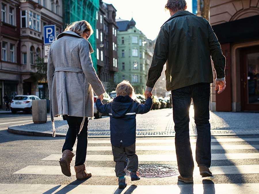 A young family crossing the street